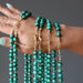 malachite necklaces draped over hand