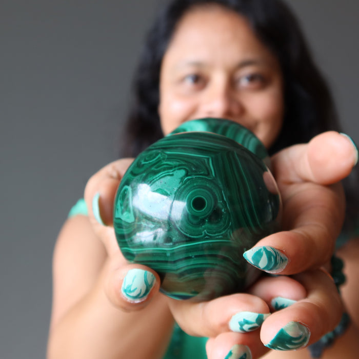 sheila of satin crystals holding a malachite sphere