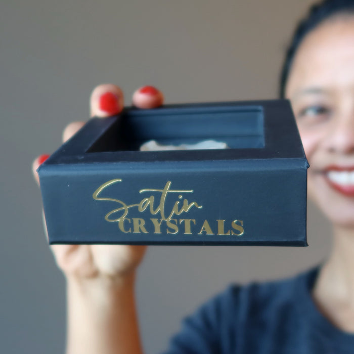 sheila of satin crystals holding up a libyan desert glass in a floating case