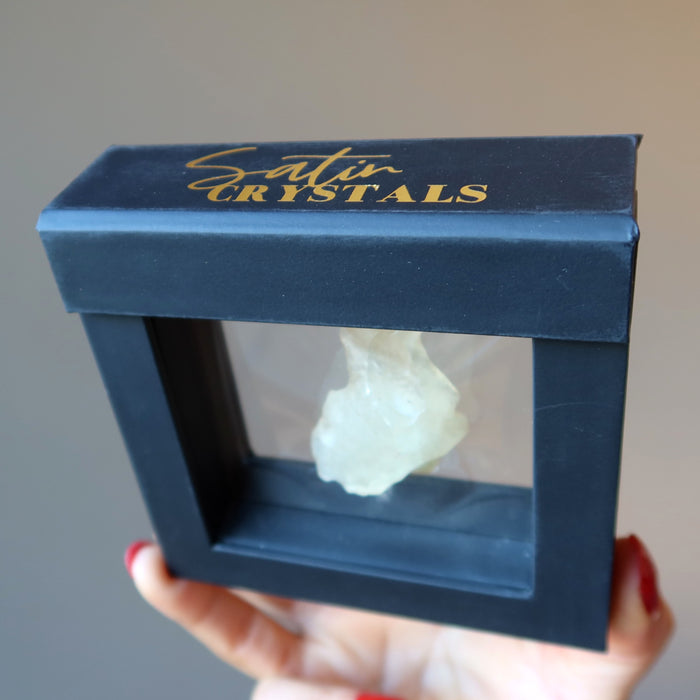 hand holding up a libyan desert glass in a floating case