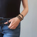 female with hand in jeans pocket wearing 3 mica oval bracelets