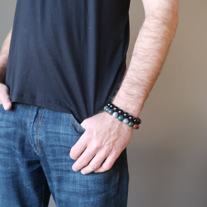 male hand in jeans pocket modeling bloodstone and rainbow obsidian bracelet set