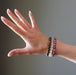 woman's hand modeling chrysocolla cuprite, rose quartz, rhodonite bracelet set