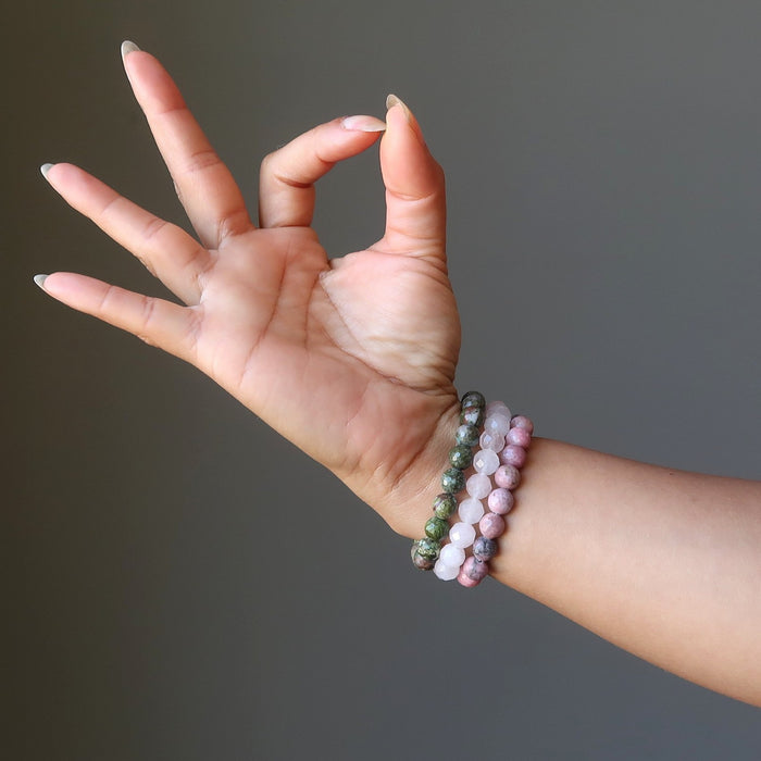 hand making an okay symbol modeling chrysocolla cuprite, rose quartz, rhodonite bracelet set