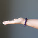 female hand wearing amethyst bracelet 