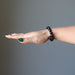 female hand wearing black tourmaline bracelet