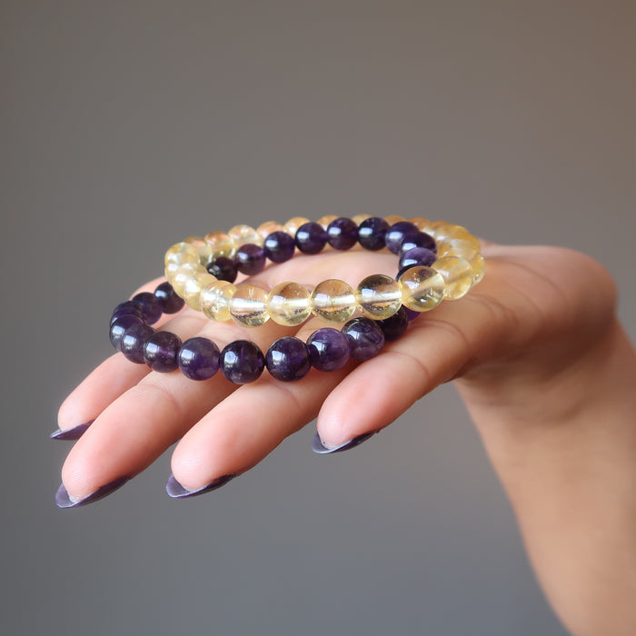 female hand holding amethyst and citrine bracelet set