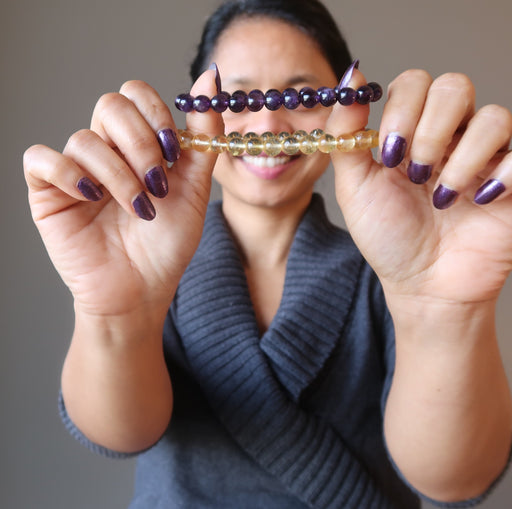 sheila of satin crystals holding up citrine and amethyst bracelets
