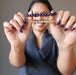 sheila of satin crystals holding up citrine and amethyst bracelets