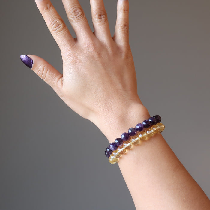 female hand modeling amethyst and citrine bracelet set