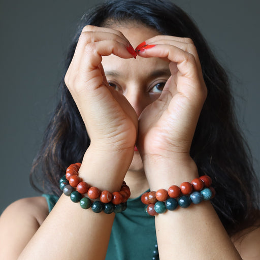 sheila of satin crystals wearing Red Jasper and Green Bloodstone beaded stretch bracelet sets on both wrists
