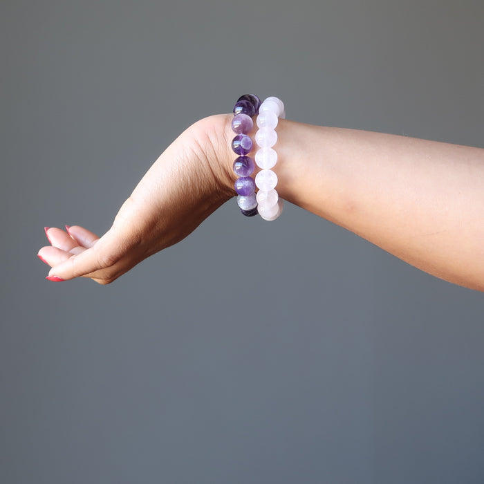 female hand wearing amethyst and rose quartz bracelet sets