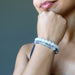 Sheila of Satin Crystals has her head to her chin white wearing the selenite fluorite stretch bracelet set