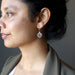 woman modeling moldavite garnet earrings