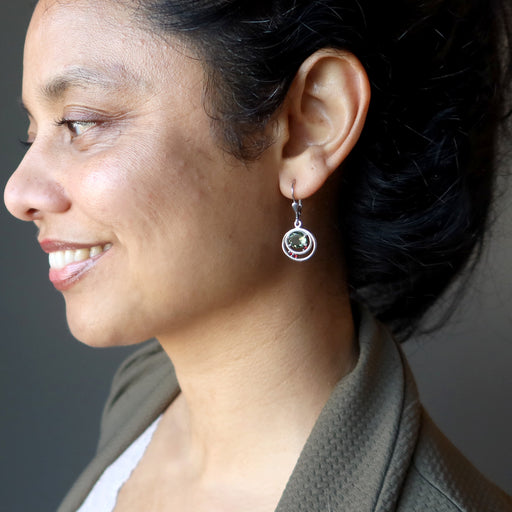woman modeling moldavite garnet earrings