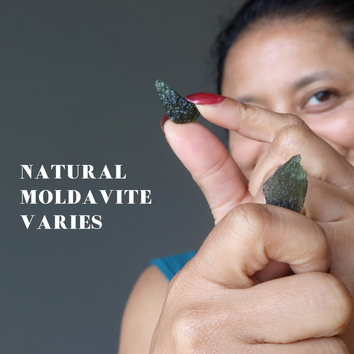 sheila of satin crystals holding up two  moldavite to show pattern variations