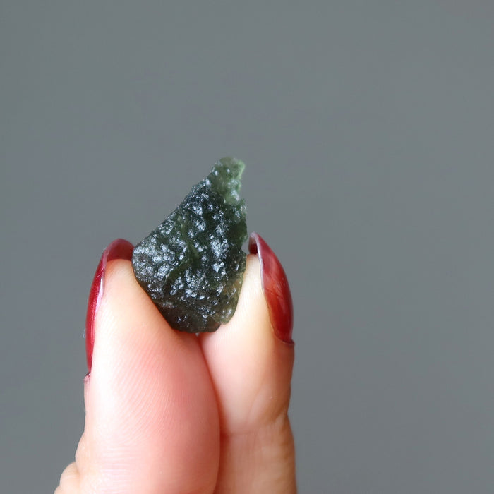 hand holding up a moldavite