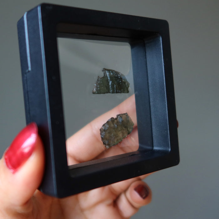 pair of moldavite rough gemstones in meteorite display case