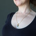 raw moldavite on gold necklace chain on female model