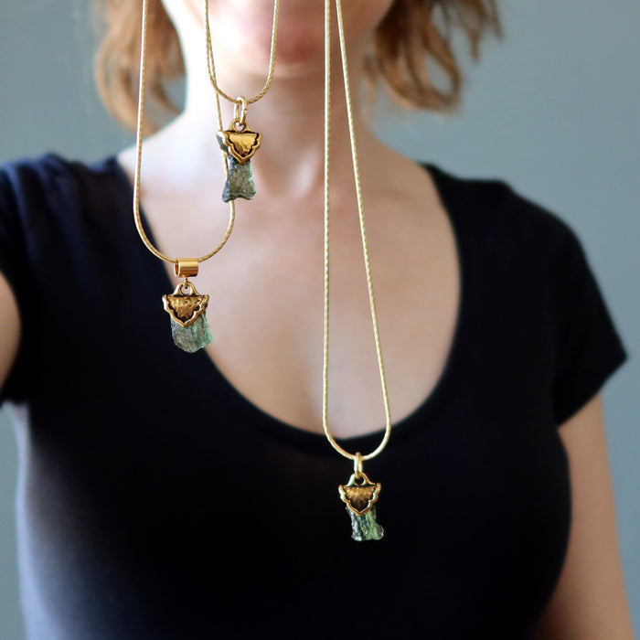 three moldavite necklaces on gold chains
