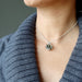 female model wearing moldavite tumbled sterling silver cage necklace