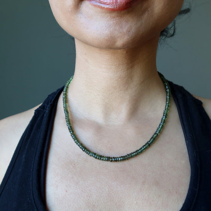 female wearing moldavite faceted necklace