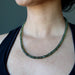 female wearing moldavite faceted necklace