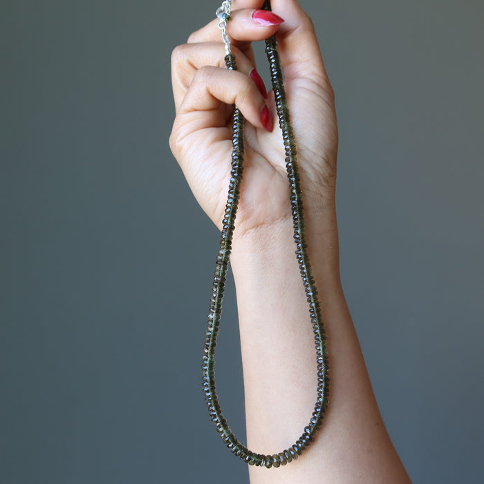 hand holding moldavite necklace
