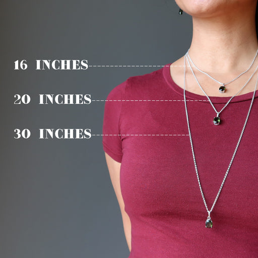woman modeling three moldavite necklaces to show different lengths