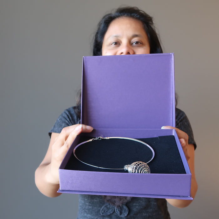 sheila of satin crystals holding a moldavite cage necklace in purple satin crystals gift box
