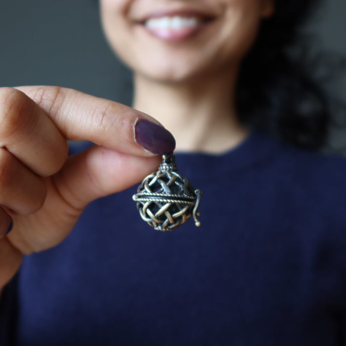 hand holding moldavite pendant at chest