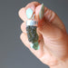 hand holding raw green moldavite pendant