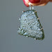 hand holding large raw moldavite in sterling silver pendant