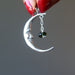 hand holding sterling silver crescent moon with faceted green moldavite pendant