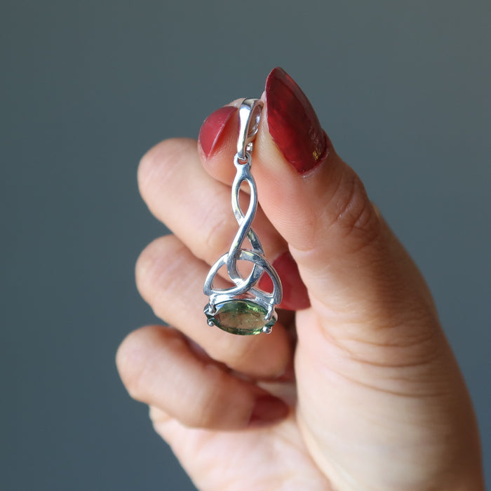 hand holding moldavite pendant