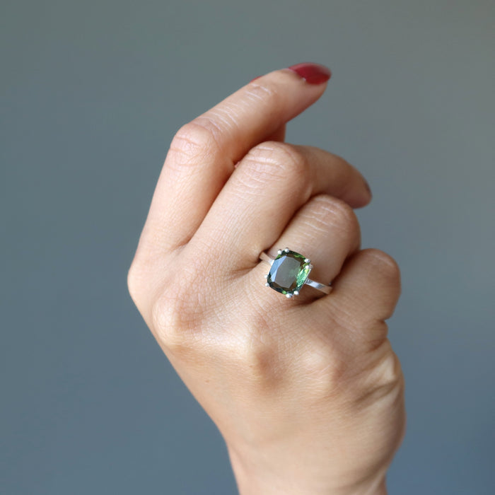 hand wearing moldavite ring on finger