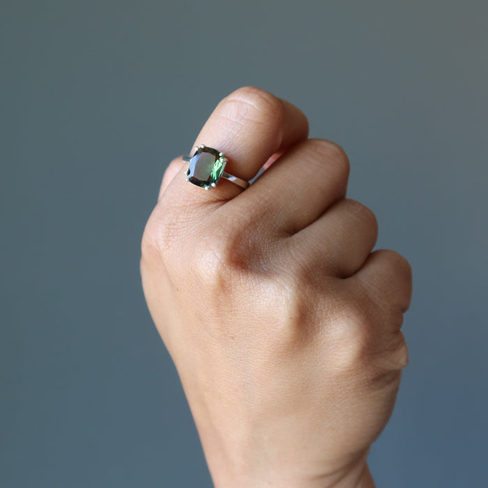 hand wearing moldavite ring on finger