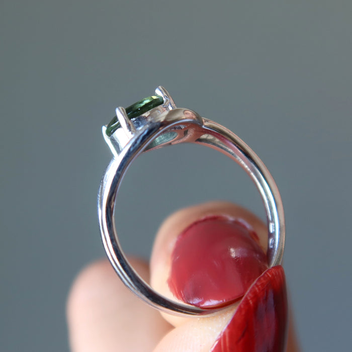 hand holding a moldavite faceted ring on the finger