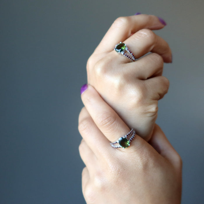 two hands modeling moldavite garnet rings