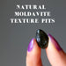 hand holding moldavite with textured pits