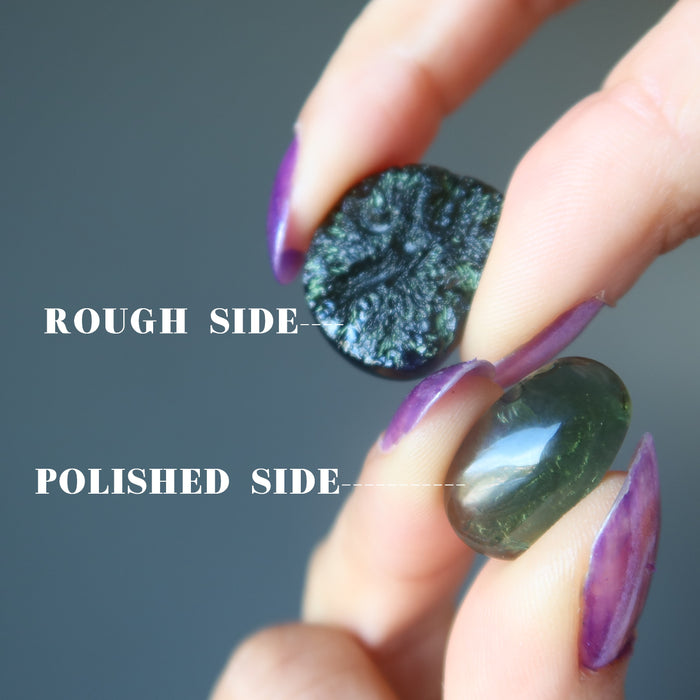 hands holding two moldavite showing rough side and polished side
