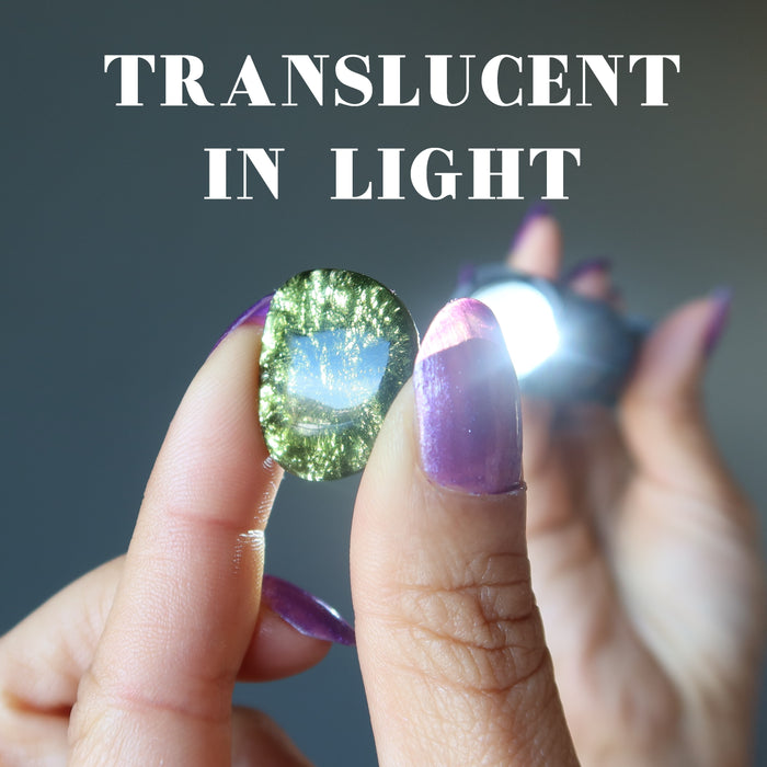 shining a flashlight through moldavite to show translucency