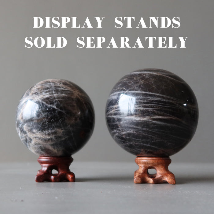 two black moonstone spheres on fancy wood display stands, which are sold separately