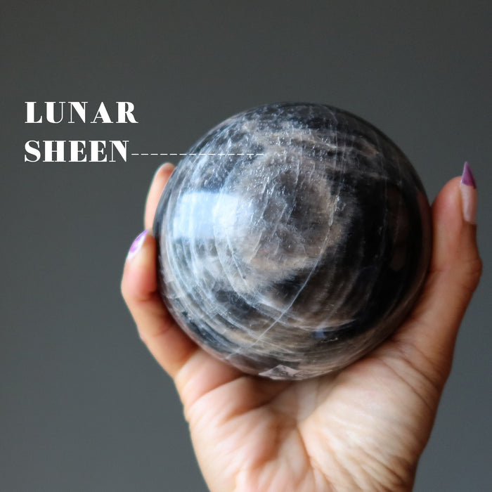 hand holding black moonstone sphere with lunar sheen