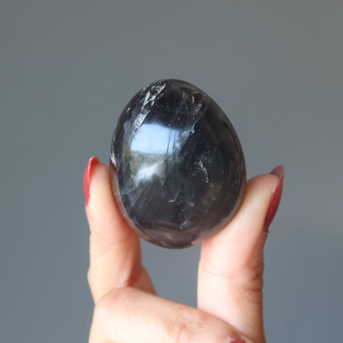 sheila of satin crystals holding black moonstone palm stone