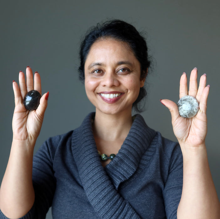 sheila of satin crystals holding black moonstone palm stones