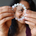 sheila of satin crystals with a white moonstone and pink rose quartz round beaded stretch bracelet in front of her face