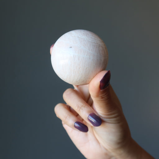 hand holding cream moonstone sphere