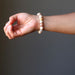 woman's hand wearing yellow peach moonstone round stretch bracelet