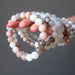 hand holding a bunch of moonstone beaded bracelets